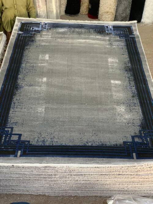 Modern Geometric Border Area Rug with a distressed or faded effect in shades of grey and blue