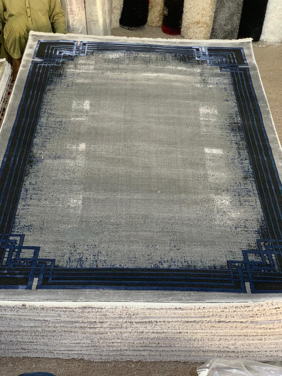 Modern Geometric Border Area Rug with a distressed or faded effect in shades of grey and blue