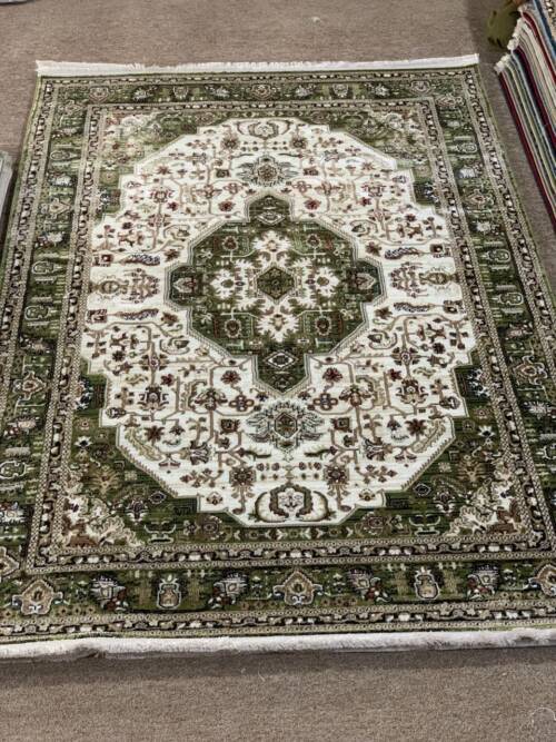 Traditional green Persian-style area rug with its central medallion and intricate patterns
