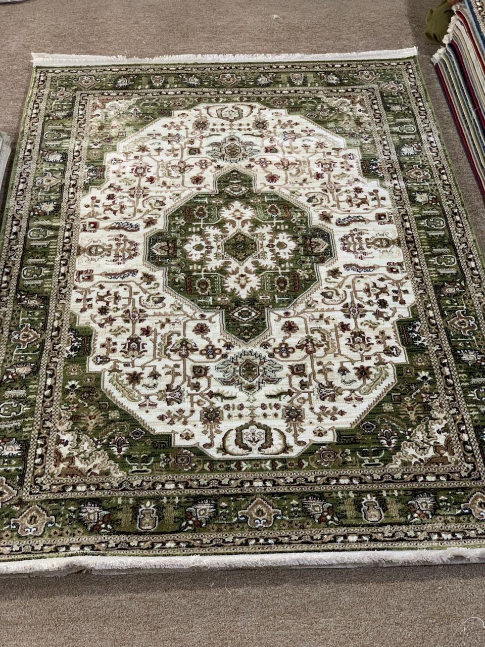 Traditional green Persian-style area rug with its central medallion and intricate patterns